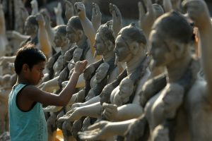 A young Idol maker in Kumartuli painting the faces of the goddesses